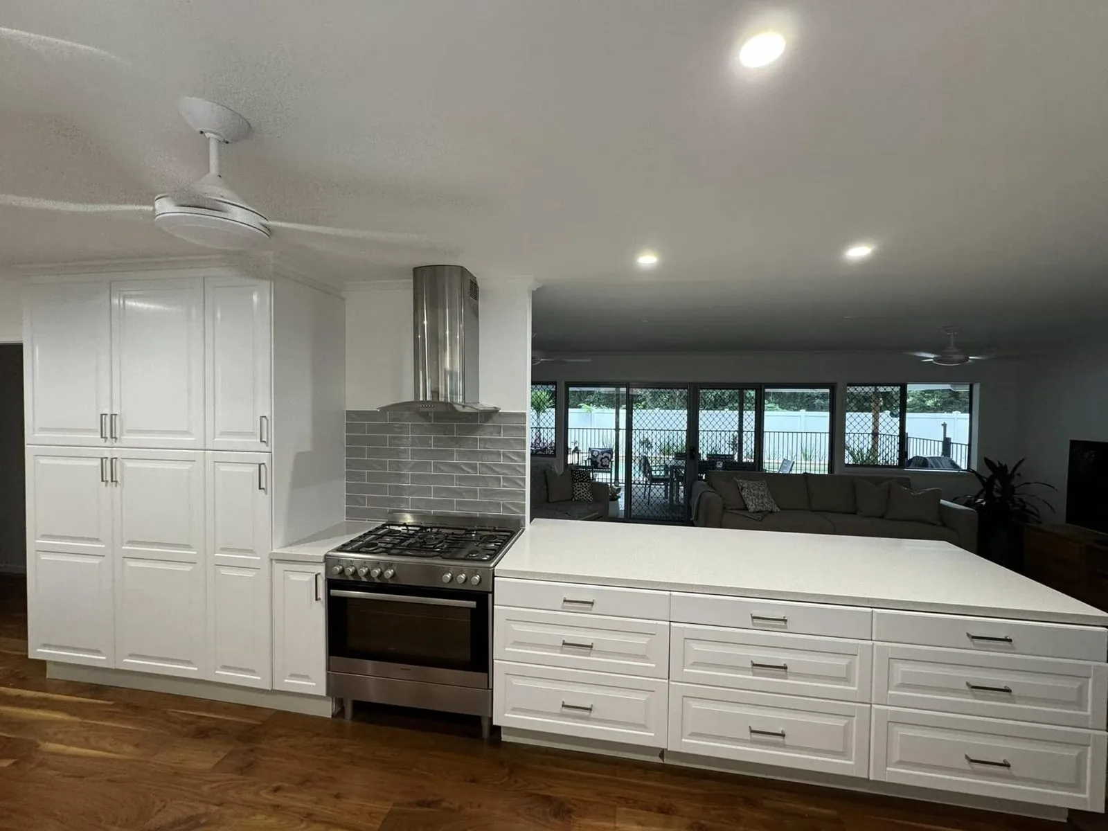 Kitchen with white panelled cabinets and a steel oven