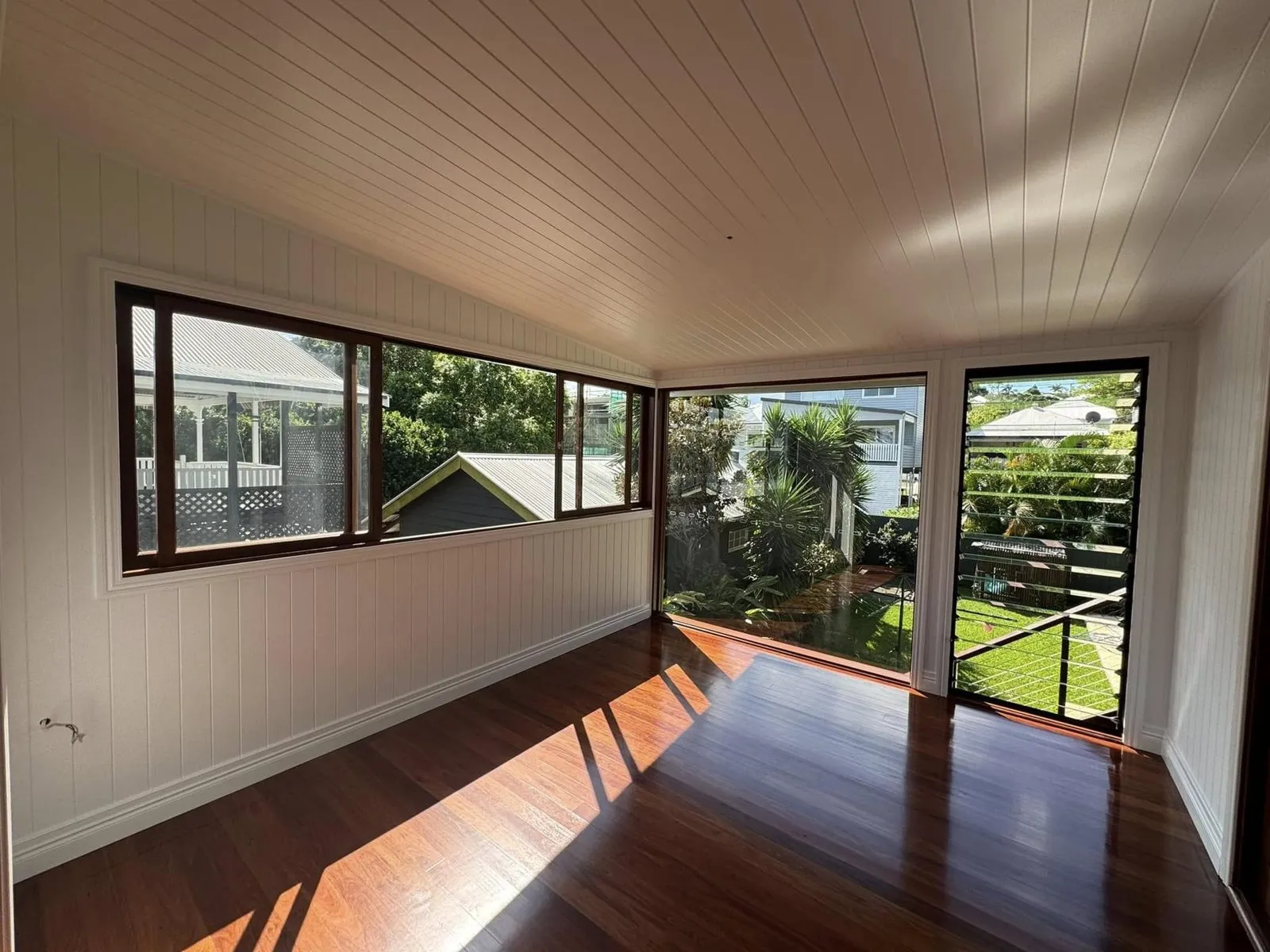 Room with white walls, a white lined ceiling and oiled timber floors in a West End extension