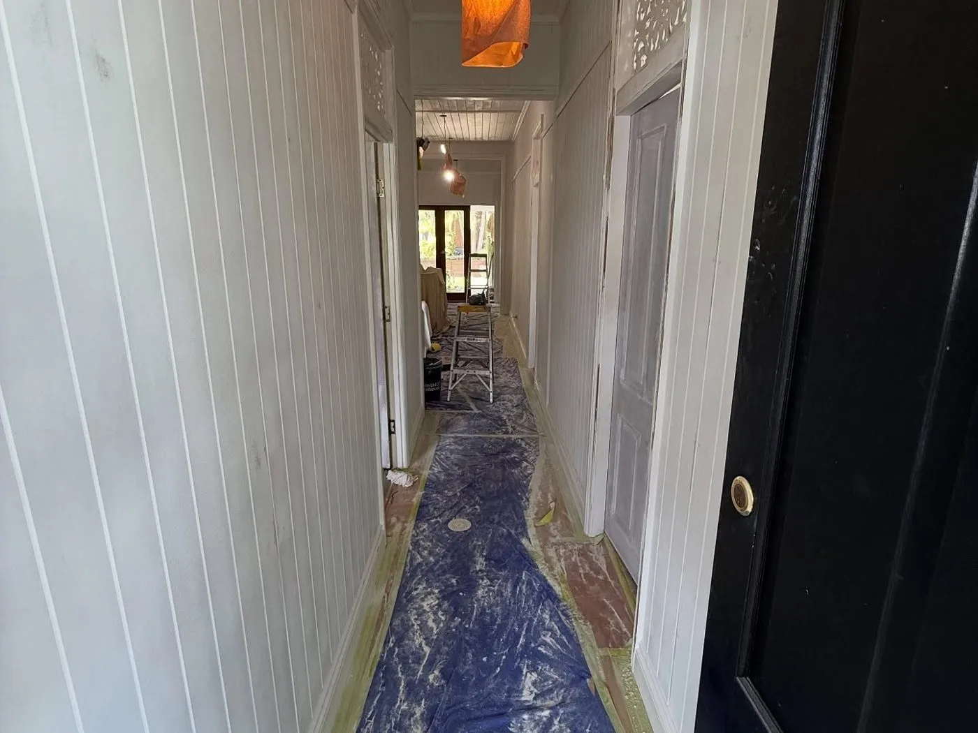 Hallway floor covered in protective sheeting before painting